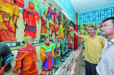 襄陽一老人在自辦的“三國人物泥塑館”為參觀者介紹自己的泥塑作品。
